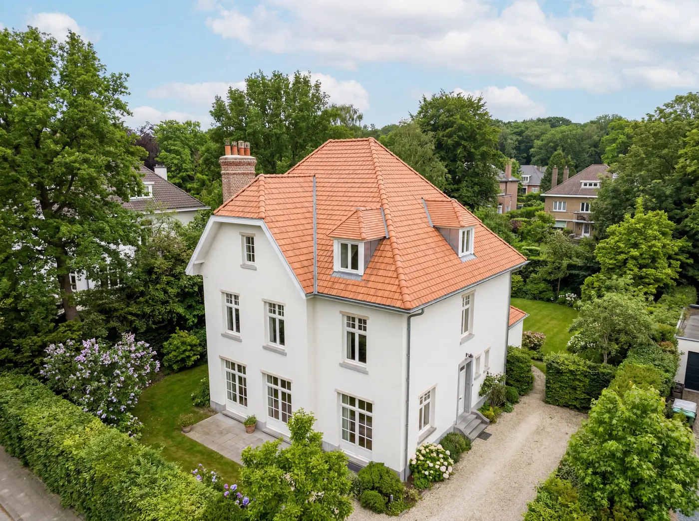 Vue drone d'une villa blanche avec toiture neuve en tuiles oranges, posée par un couvreur professionnel à Bruxelles